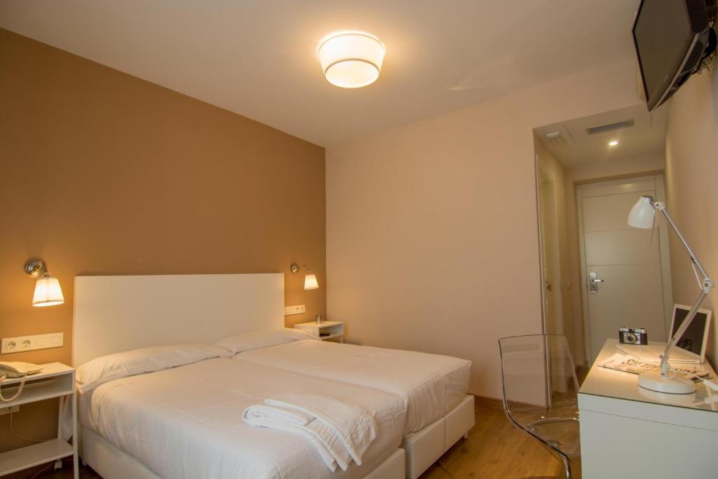 托莱多络丝思加雷斯酒店的卧室配有白色的床和镜子