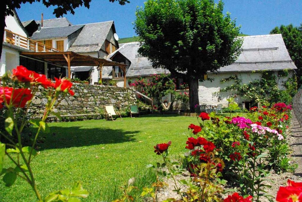 CathervielleGite Auberge La Soulan - gite de montagne的一座带红色花的院子的房子