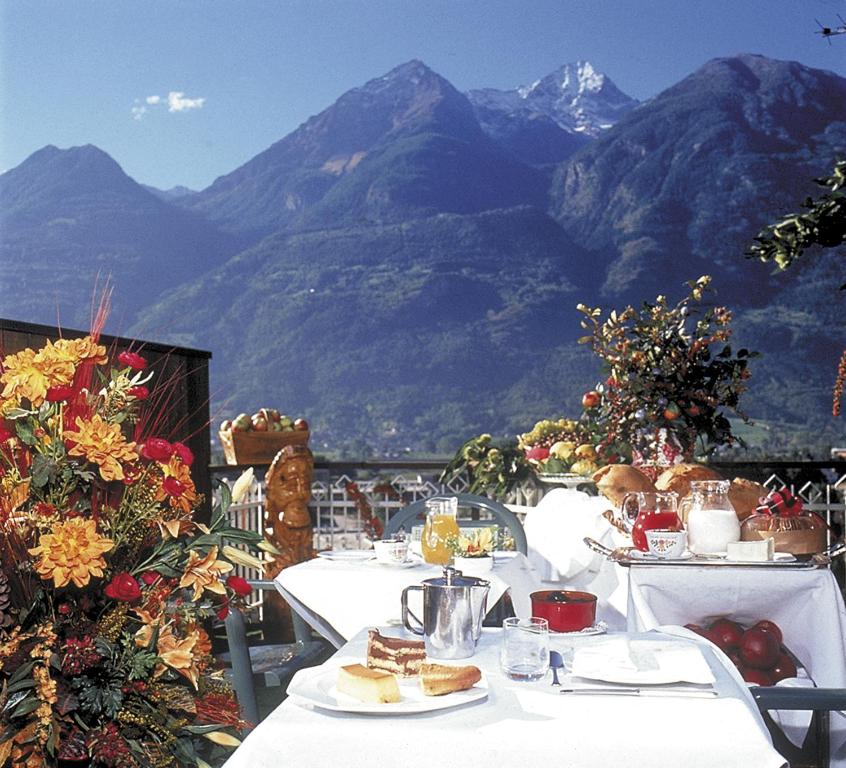 奥斯塔Hotel Casale的一张桌子,上面有食物,后面有山