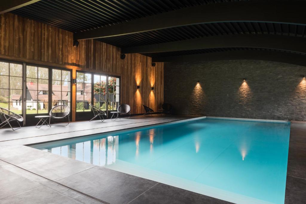 Saint-Jouin-Bruneval凯撒的松树 - 埃特勒特运动酒店的大楼内一个蓝色的大型游泳池