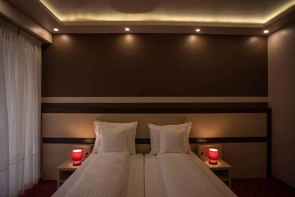 霍莫罗德浴场Homorod Hotel的一间卧室配有一张带两个红色蜡烛的床