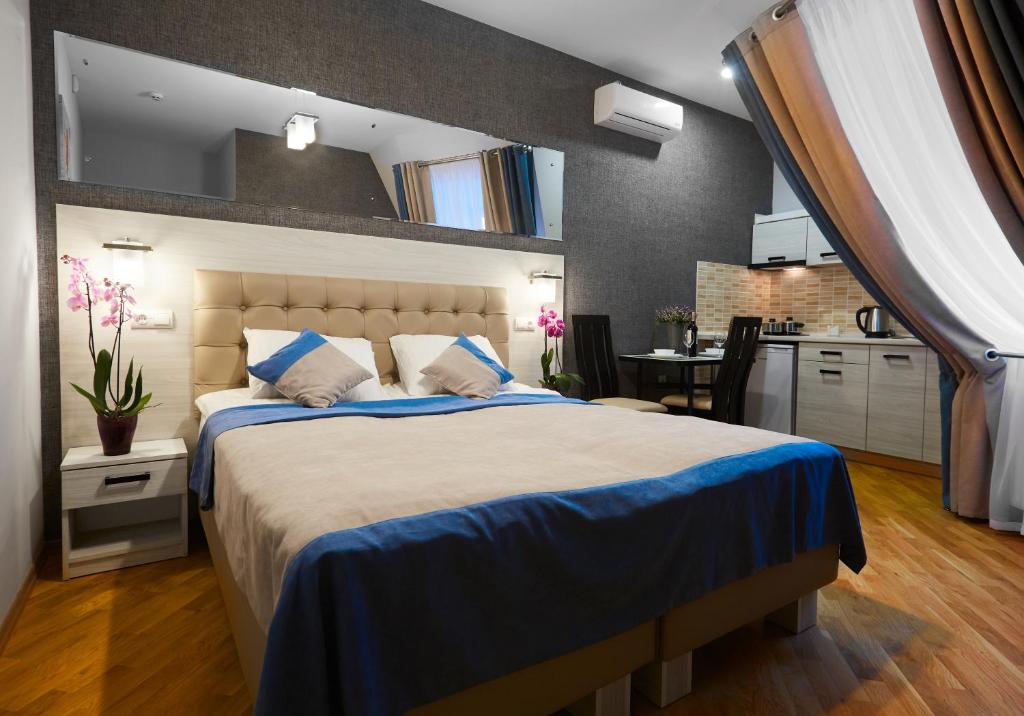 利沃夫ANTARES Apart hotel的一间带大床的卧室和一间厨房