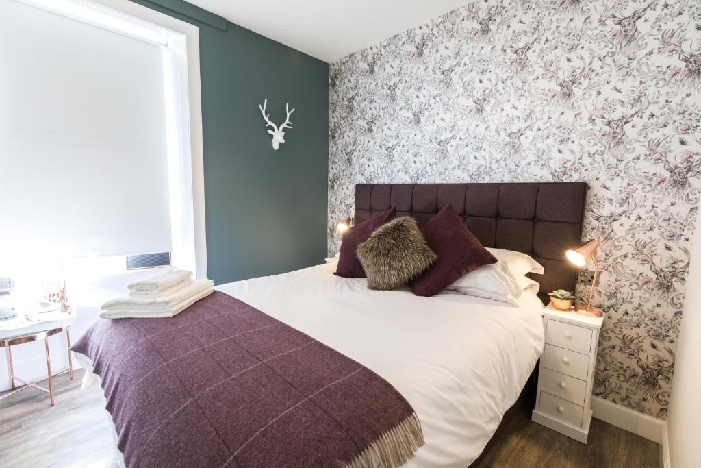 爱丁堡托芬酒店的一间卧室配有一张大床和紫色毯子