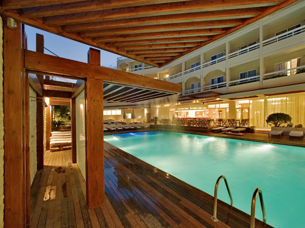 罗德镇阿斯尼恩酒店的一座带木甲板的酒店的大型游泳池