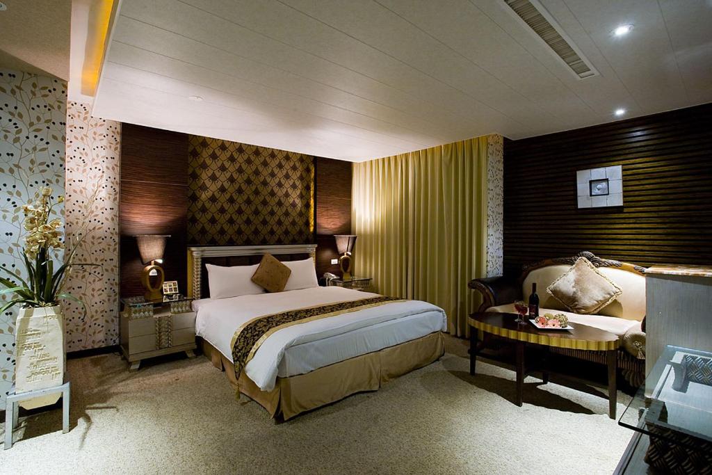 新竹新竹水晶旅馆的酒店客房配有一张床、一张书桌和一张四柱床