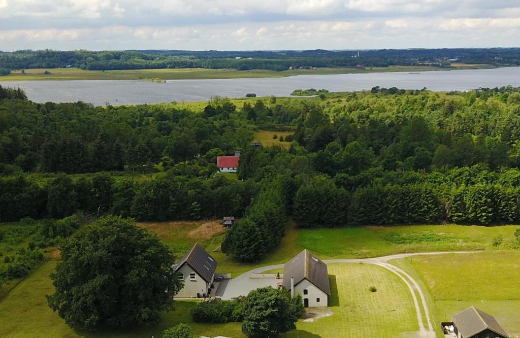 锡尔克堡Bøllingsø Feriehus的湖畔田野上房屋的空中景观