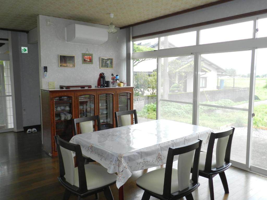 TaragiB&B Toyonoakari的一间配备有白色桌椅的用餐室