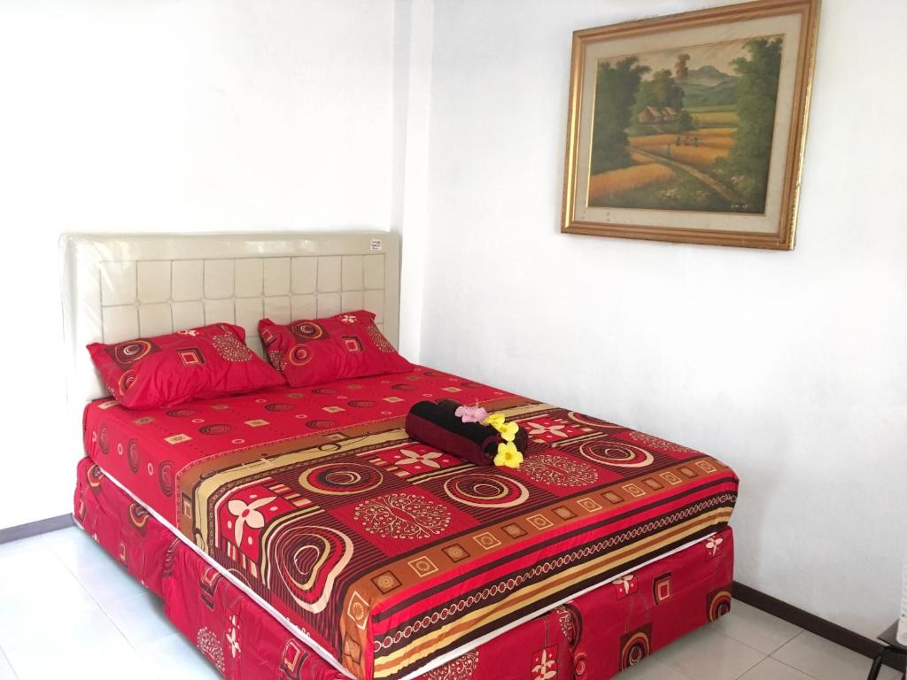 茂物Indekost Bogor的墙上一张红色的床
