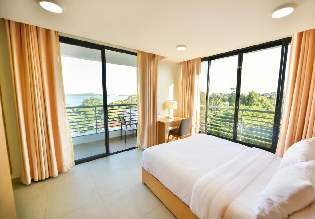 恩德培K Hotels Entebbe的一间卧室设有一张大床和大窗户