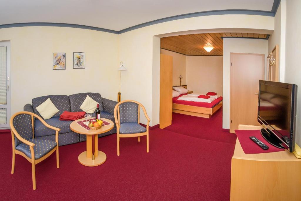 维林根Schröder's Hotelpension的带沙发、桌子和床的房间