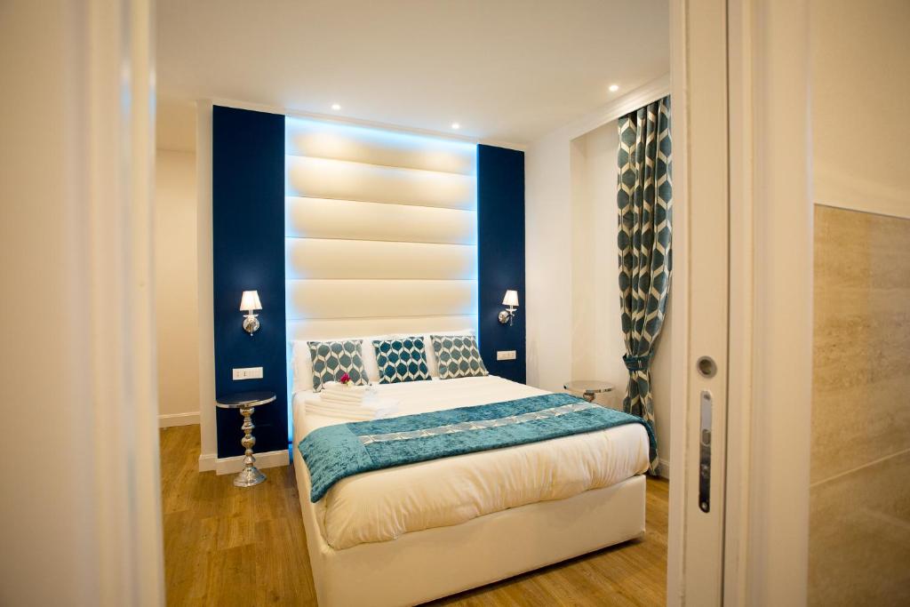 斯培西亚阿特姆斯菲旅馆 - 拉斯佩齐亚渔村的一间卧室配有一张蓝色墙壁的床