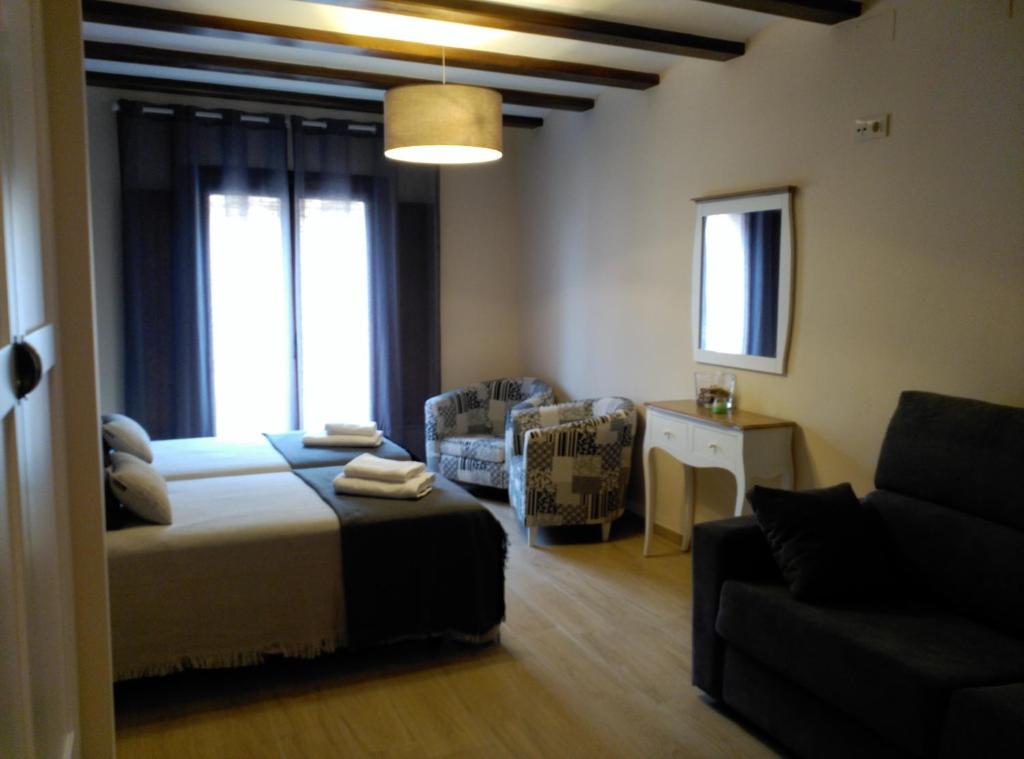 TronchónEl Rincón del Gallo的一间卧室配有一张床、一把椅子和一张沙发