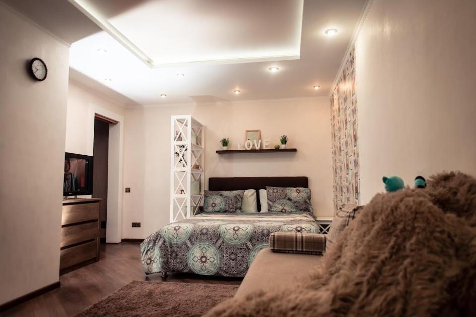 切尔尼戈夫Бирюзовый стиль的一间卧室配有一张床和一台电视