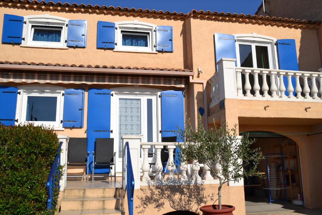 维多邦Résidence Niccola的蓝色的房子,设有白色窗户和蓝色百叶窗