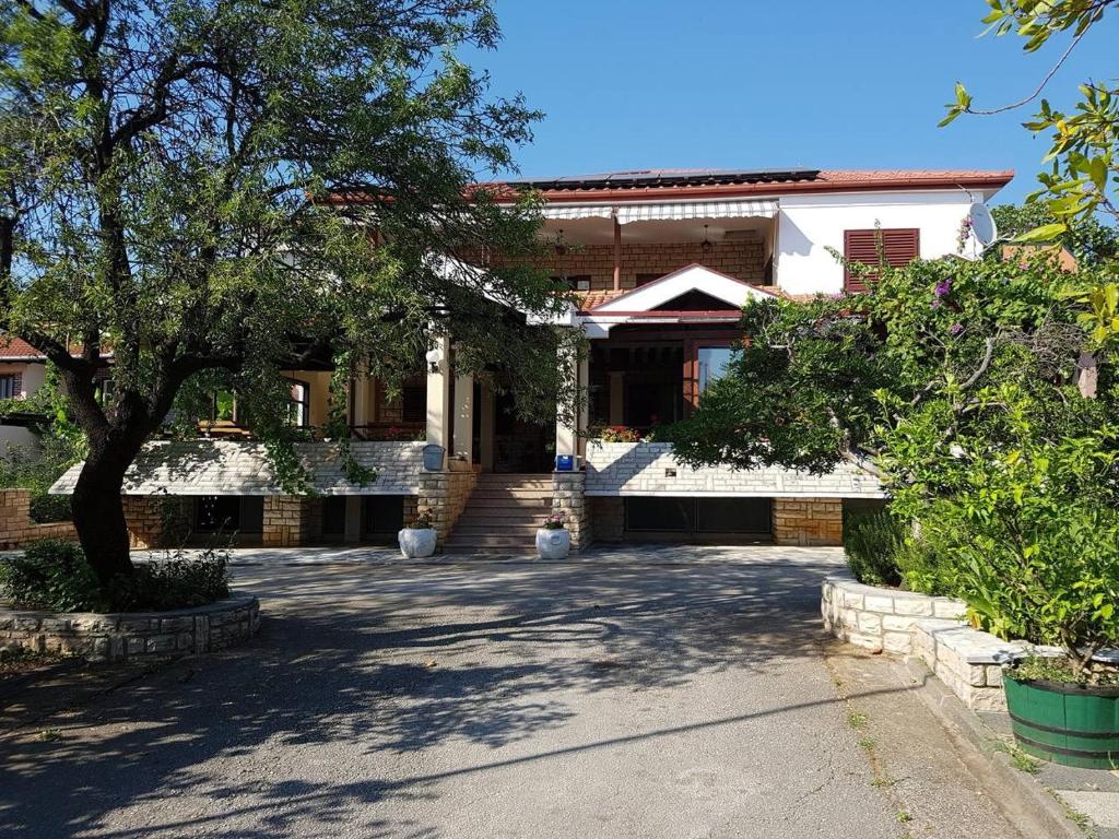 斯塔利格拉德-帕克利尼卡Apartments in Starigrad-Paklenica 33853的前面有一棵树的房子