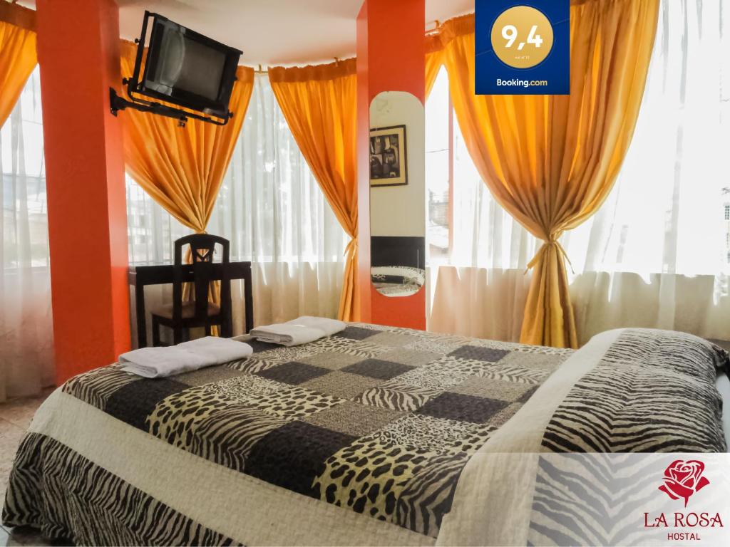 奥塔瓦洛Hostal La Rosa Otavalo的一间卧室配有橙色墙壁和窗帘的床