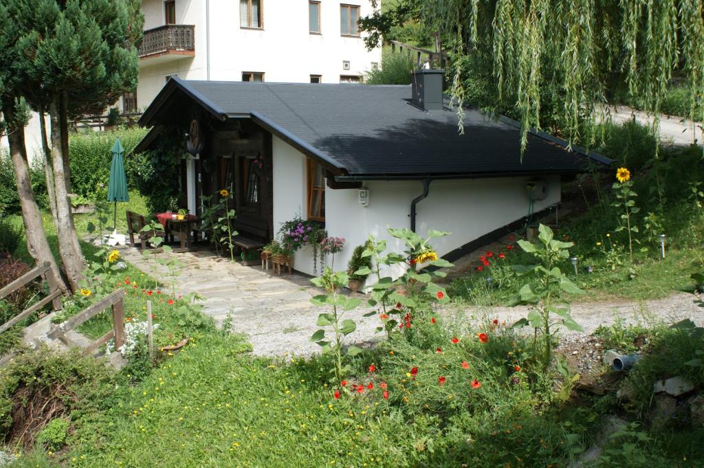 列兴Ferienwohnungen Wilhelmer的一座带黑色屋顶的小房子和一个花园