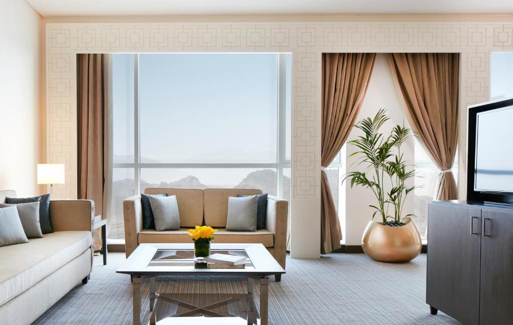 富查伊拉Royal M Hotel Fujairah by Gewan的带沙发和电视的客厅