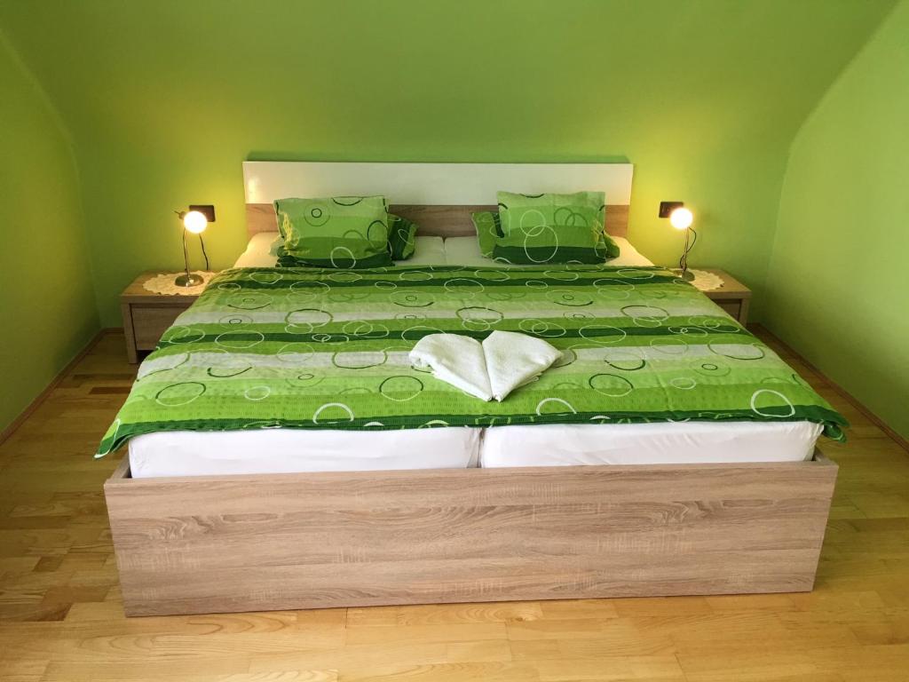 比克内梅特旅馆的一间卧室配有一张带绿色棉被的大床