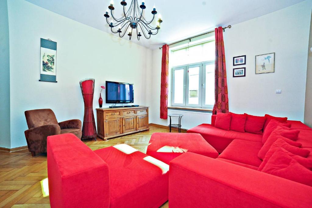 索波特Red Apartment Czyżewskiego by Grand Apartments的客厅配有红色沙发和电视