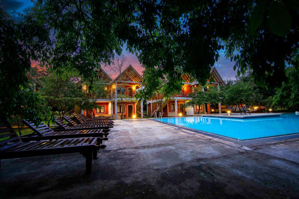 锡吉里亚Elephas Resort & Spa的房屋前带躺椅的游泳池