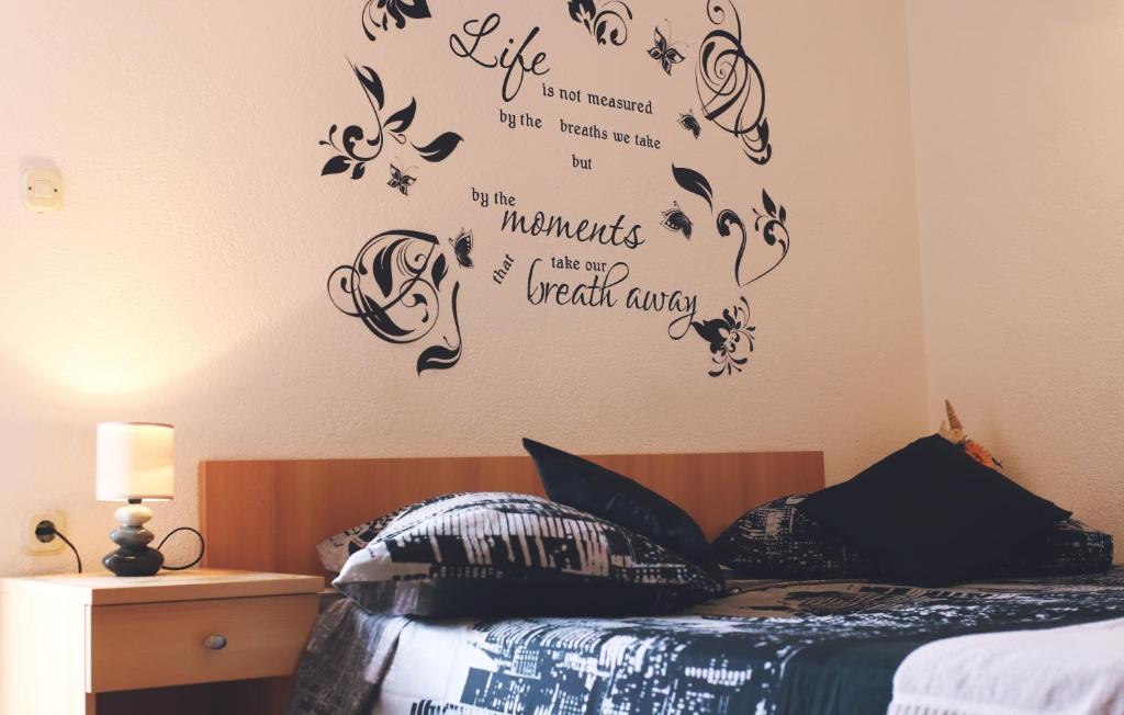 巴什卡沃达Apartment & Rooms Marigold的卧室配有一张墙上写着字条的床