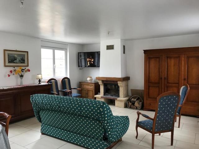Beaumont-Hamelle clos du caribou的客厅配有沙发、椅子和壁炉