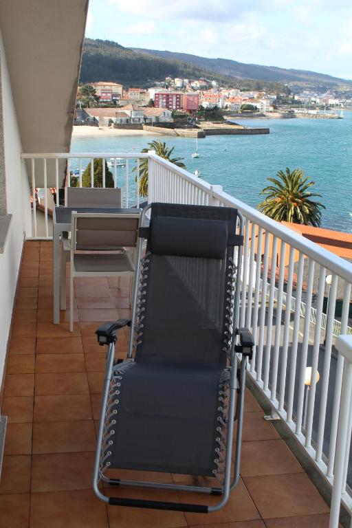 科尔库维翁Apartamento Praia de Quenxe的阳台配有椅子,享有水景
