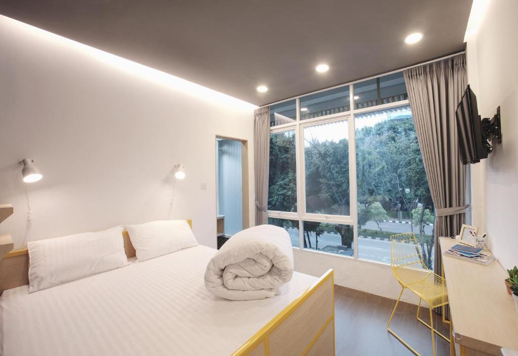 雅加达雅加达孔科旅舍的一间卧室配有一张带椅子的床和一扇窗户