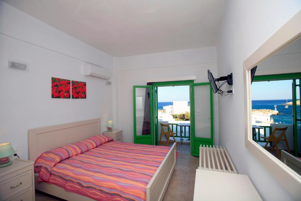 AloproniaKastellos Apartments Sikinos的一间卧室设有一张床和一个海景阳台