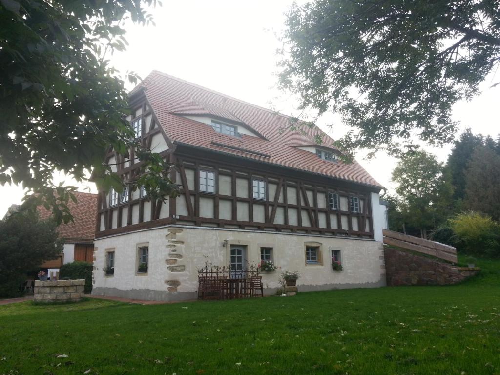 梅森Ferienwohnung "Alte Bauernstube"的绿色田野上一座红色屋顶的老房子