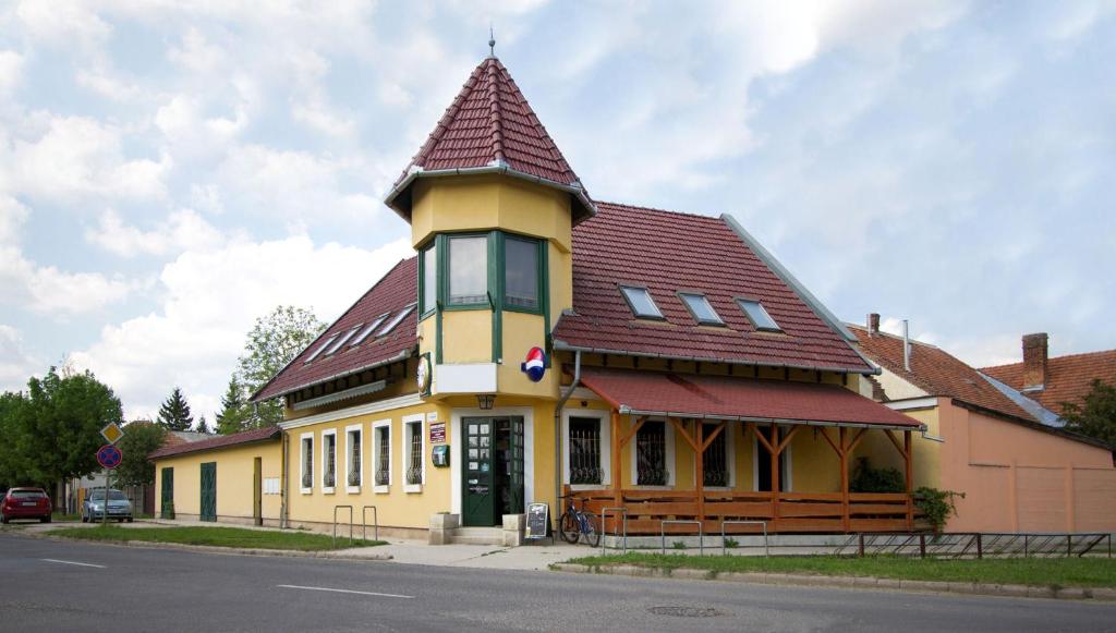 贝凯什乔包Alíz Vendégház的红色屋顶的大型黄色建筑
