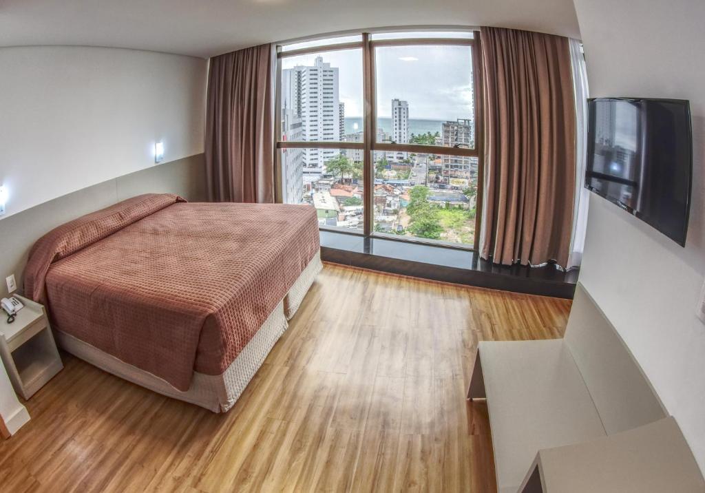 累西腓Marante Executive Hotel的酒店客房设有一张床和一个大窗户