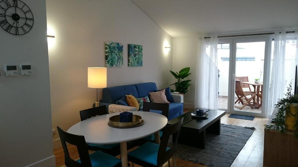 里斯本Tauro 195 near El Corte Ingles的客厅配有桌子和蓝色沙发