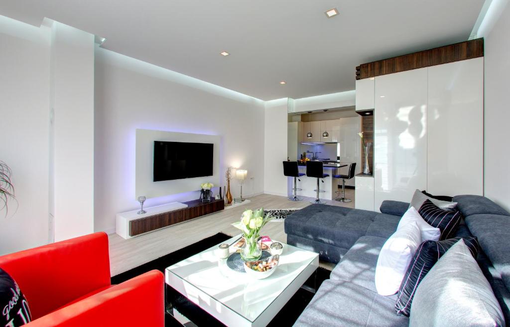 莫斯塔尔Luxury apartment CRYSTAL的客厅配有蓝色的沙发和红色的椅子