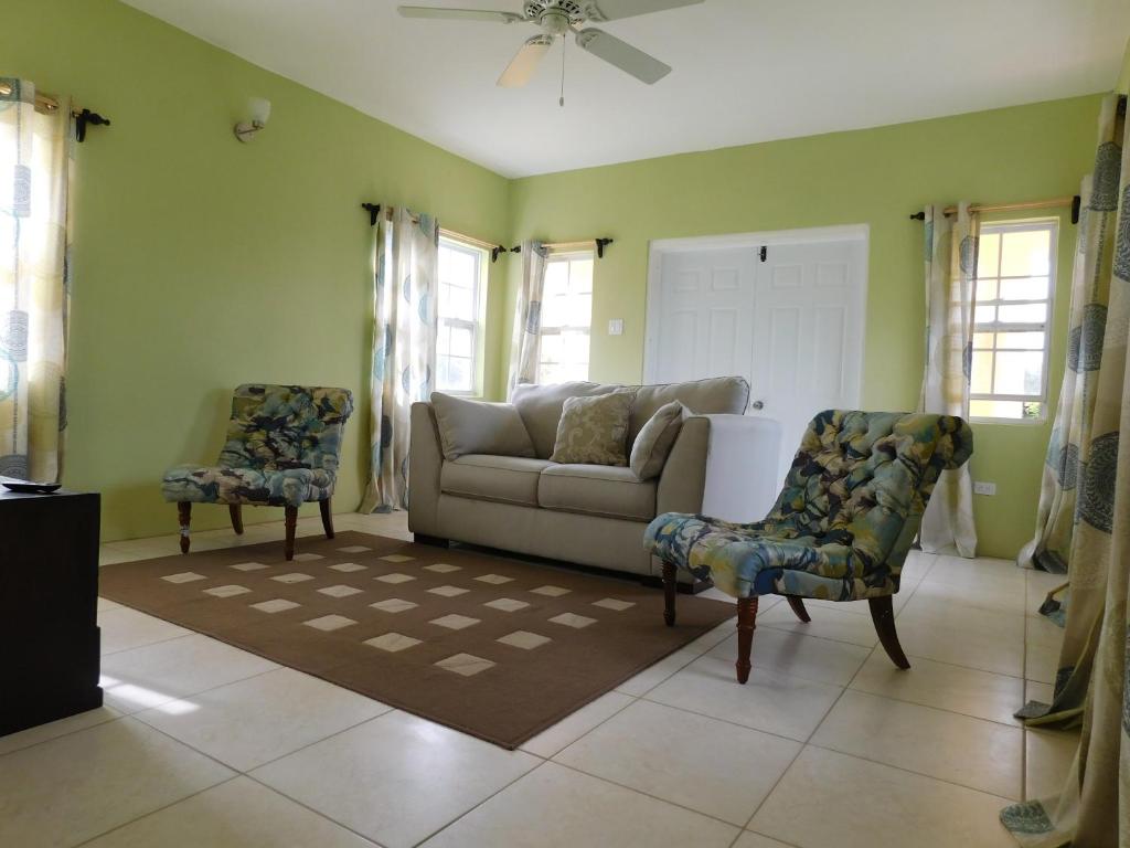OgeeʼsValley View Property的客厅配有沙发和两把椅子