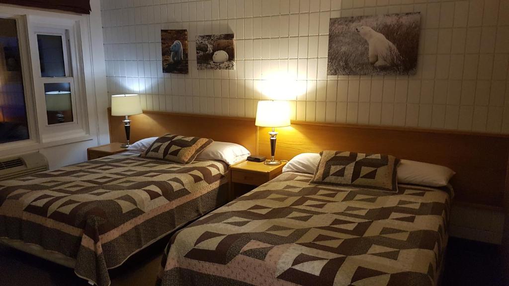 PinawaPinawa Motel的酒店客房设有两张床和两盏灯。