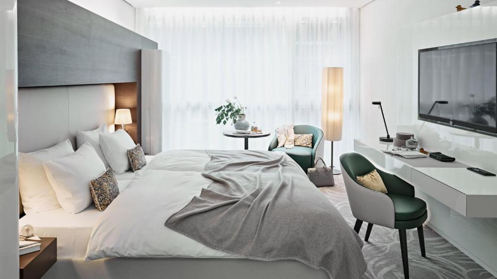 汉堡SIDE, Hamburg, a Member of Design Hotels的一间卧室配有一张床、一张书桌和一台电视