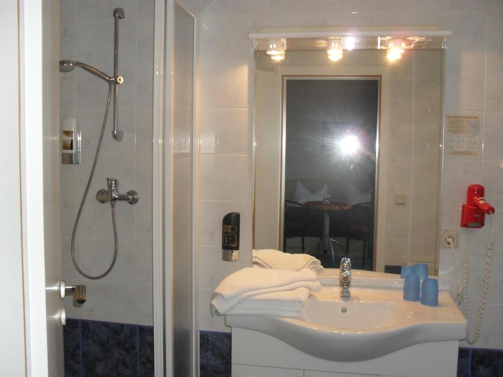 吕根岛上的维克Hotel-Pension Zur Mole的浴室配有盥洗盆和带镜子的淋浴