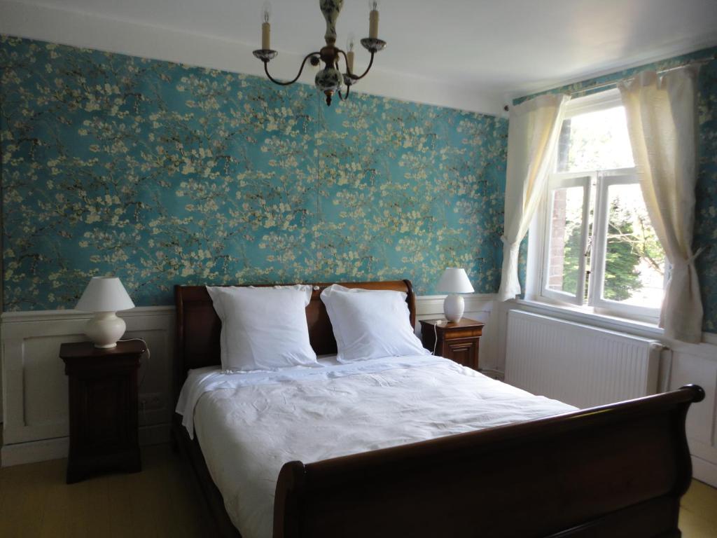图尔奈Villa Tournesol的一间卧室配有一张带绿色花卉壁纸的床