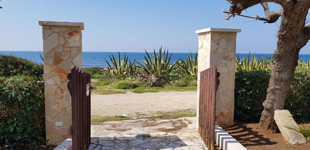 托雷苏达Villa Rosaria的通往海滩的大门,海滩的背景是大海