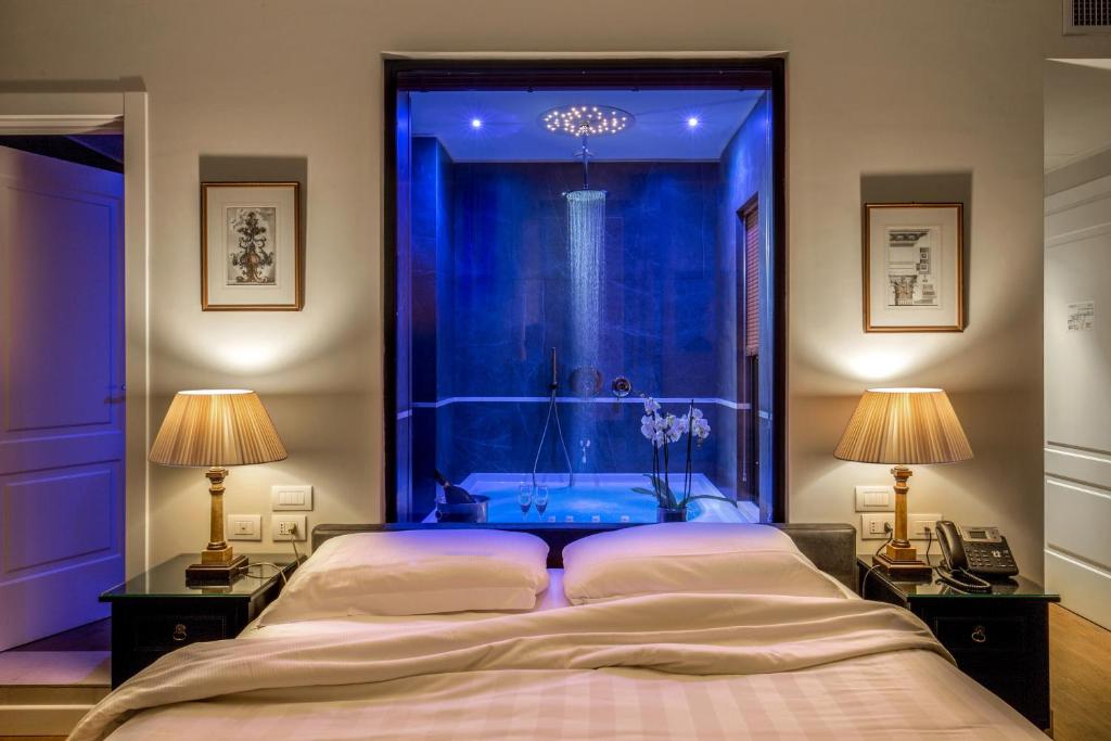 罗马蒙特桑西酒店的一间卧室设有蓝色的房间,配有一张床和两盏灯