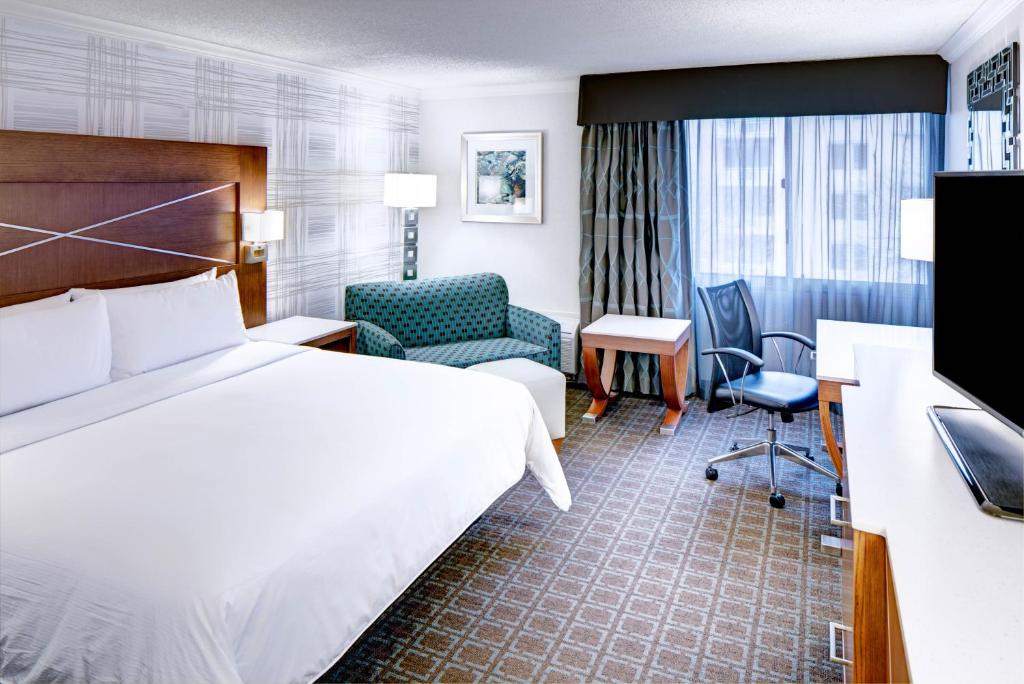 麦迪逊DoubleTree by Hilton Madison Downtown的配有一张床和一把椅子的酒店客房