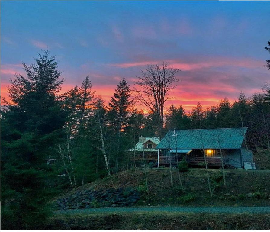 帕克伍德Packwood Ski & Vacation Getaway的山丘上的房子,背景是日落