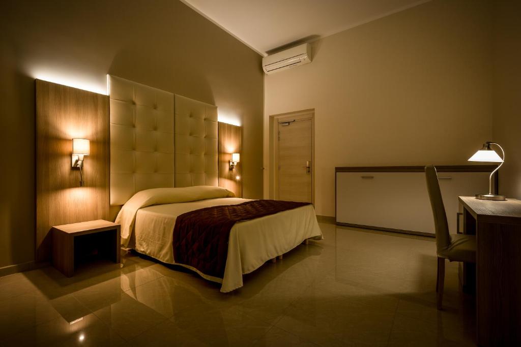 热那亚贝尔索吉奥诺酒店的一间卧室配有一张床、一张桌子和一张书桌