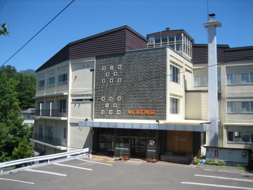 登别登别鲁鲁苏温泉汤原庄日式旅馆的前面有停车位的大楼