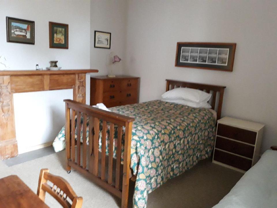 奥玛鲁维拉度假屋的一间卧室配有一张床、梳妆台和婴儿床。
