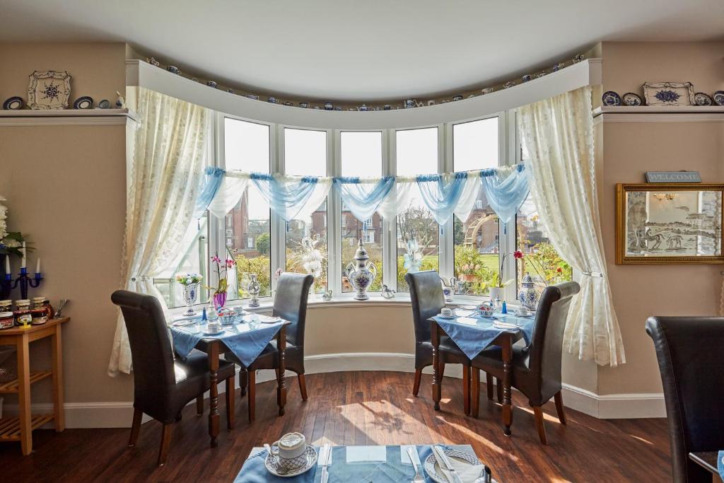 大雅茅斯Barons Court的一间带桌椅的用餐室和大窗户