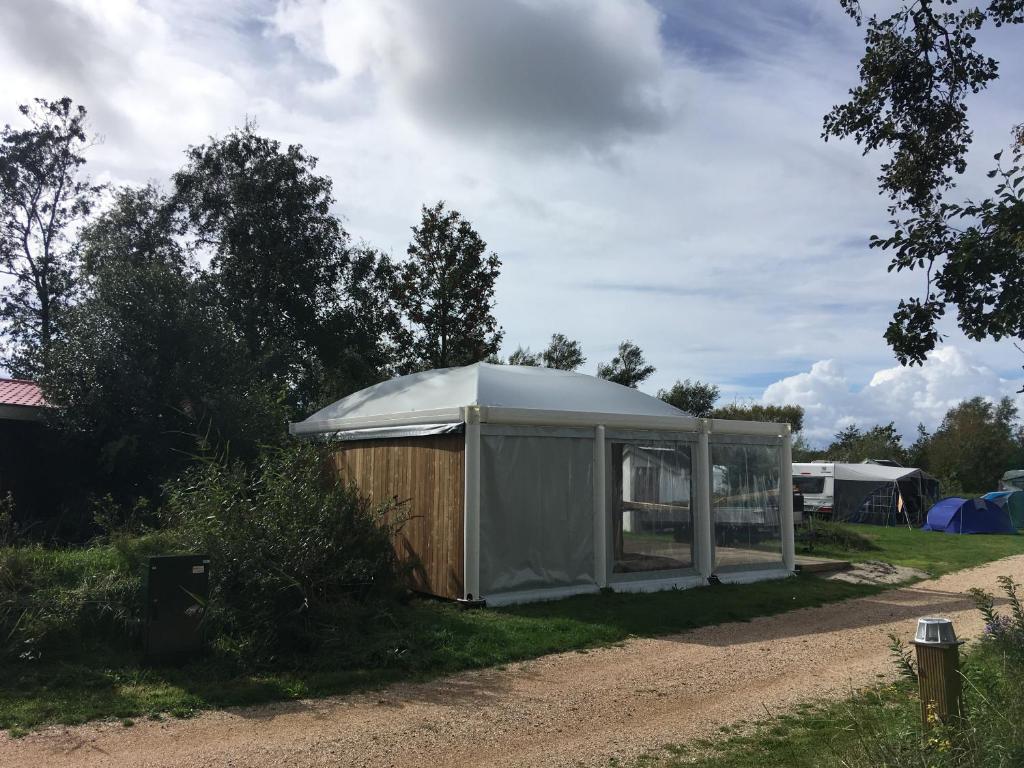 Sint MaartensvlotbrugSafaritent glamping tent nabij Sint Maartenszee的土路一侧的帐篷