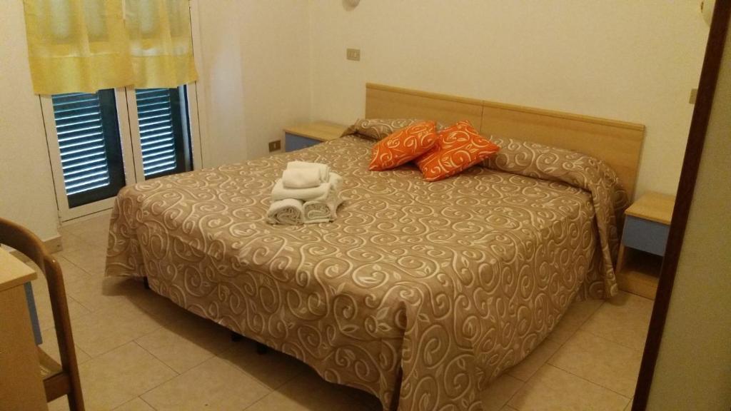 伦诺Albergo Ristorante Lavedo的一间卧室配有一张床,上面有两条毛巾
